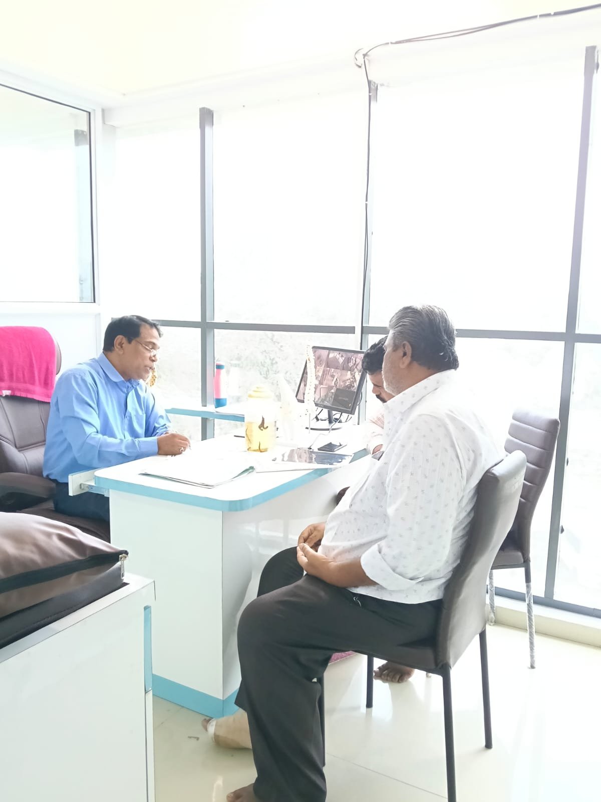 Dr. Pandurang Ramchandra Narale consulting with a patient